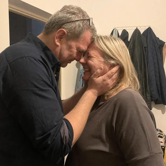 Songcover: Mann um die fünfzig nimmt das Gesicht seiner Frau in beide Hände